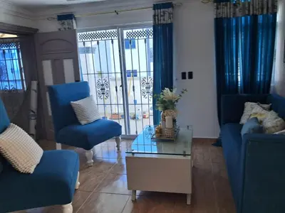 a living room with blue chairs and a glass table at Residencial Jovanny 1 in Colorado