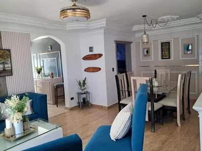 a living room with a blue couch and a dining room at Residencial Jovanny 1 in Colorado