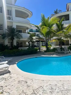 a swimming pool in front of a building at Tu refugio en Los Corales Punta Cana, wifi rápido y piscina in Punta Cana