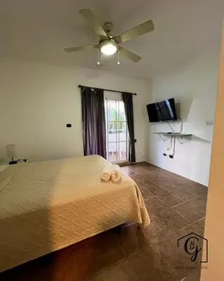a bedroom with a bed with a ceiling fan at Tu refugio en Los Corales Punta Cana, wifi rápido y piscina in Punta Cana