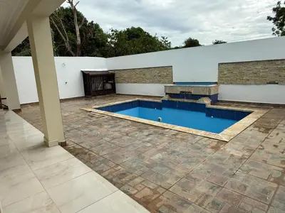 a swimming pool in a backyard with a white wall and a patio at Modern Getaway with Private Pool, Montecristi in Villa Vásquez