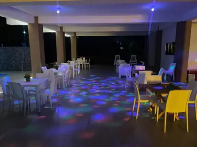 a dining room with white tables and chairs and lights at Rancho paraíso escondido in San Pedro de Macorís