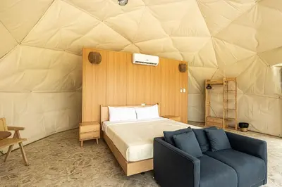 a bedroom in a dome tent with a bed and a couch at Bubble Glamping, King bed, we have a 8 units like this in Sosúa