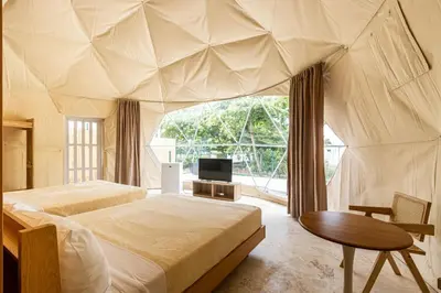 a bedroom with two beds and a table and a tv at Bubble Glamping, Family 2 beds, we have a 12 units like this in Sosúa