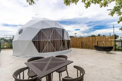 a dome tent in a backyard with a table and chairs at Bubble Glamping, Family 2 beds, we have a 12 units like this in Sosúa