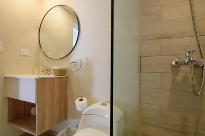 a bathroom with a shower and a toilet and a mirror at Ático ONA White Sands | Terraza & Picuzzi privado in Punta Cana
