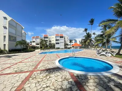 a swimming pool next to a building with a resort at comfortable apartment in La Puntica de Juan Dolio