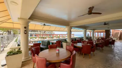 a restaurant with tables and chairs and a view of the ocean at Sosua Ocean Village - Villas Marinas 27B in Sosúa