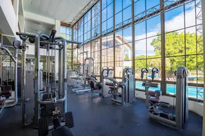 a gym with cardio equipment and a swimming pool at Sosua Ocean Village - Villas Marinas 27B in Sosúa