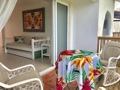 a living room with a table and chairs and a couch at Cadaques Bayahibe Family Apts in Bayahibe