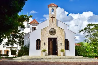 a white church with a cross on the front at Cadaques Bayahibe Family Apts in Bayahibe