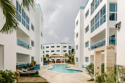 an exterior view of a building with a swimming pool at Beautiful 2 bedroom apartment on the beach in Punta Cana