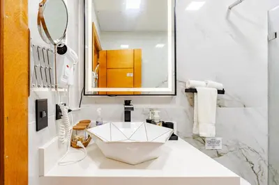 a white bathroom with a sink and a mirror at Beautiful 2 bedroom apartment on the beach in Punta Cana