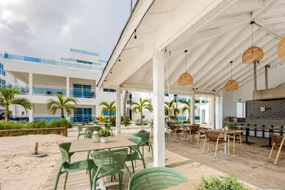 a patio with tables and chairs and a building at Beautiful 2 bedroom apartment on the beach in Punta Cana