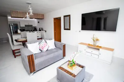 a living room with a couch and a tv at Apartment with Pool, Cofresi in San Felipe de Puerto Plata