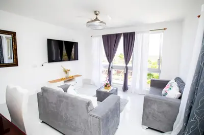 a living room with two couches and a tv at Apartment with Pool, Cofresi in San Felipe de Puerto Plata