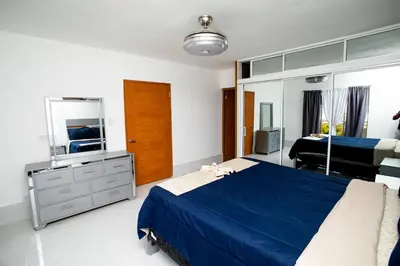 a bedroom with a blue bed and a mirror at Apartment with Pool, Cofresi in San Felipe de Puerto Plata