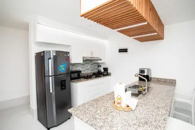 a kitchen with a stainless steel refrigerator and white cabinets at Apartment with Pool, Cofresi in San Felipe de Puerto Plata
