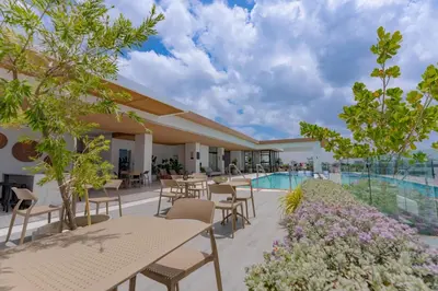 a hotel patio with tables and chairs and a swimming pool at Luxstay SDQ in Santo Domingo