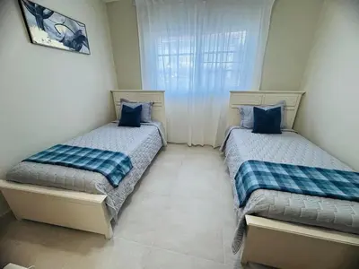two beds sitting in a room with a window at Punta Cana Apartment Tropical Escape near Beach in Punta Cana