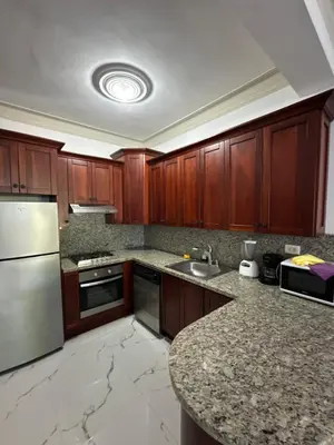 a kitchen with wooden cabinets and a granite counter top at Cabarete Town House in Cabarete