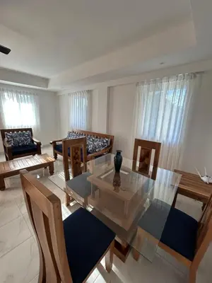 a living room with a glass table and chairs at Cabarete Town House in Cabarete