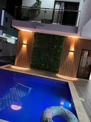 a swimming pool in a house with a green wall at Villa Joa in Punta Cana