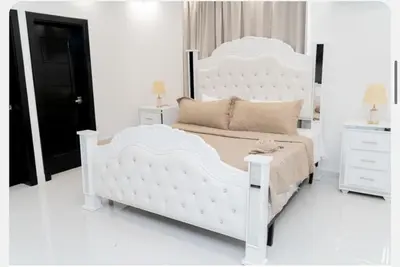 a white bedroom with a white bed and a white dresser at Villa Joa in Punta Cana