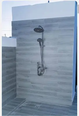 a shower in a bathroom with a wooden wall at Villa Joa in Punta Cana