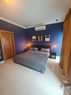 a bedroom with a bed with a blue wall at Miraculus Penthouse With Private Jacuzzi in Santo Domingo