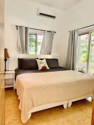 a bedroom with a large bed with two windows at Charming 2 bed 2bath villa 77B with private pool in Sosúa