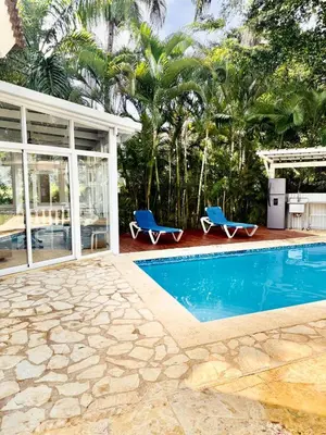 a swimming pool with two blue chairs next to a house at Charming 2 bed 2bath villa 77B with private pool in Sosúa