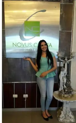 a woman is standing in front of a sign at Hotel Novus Caoba, Confort y calidez en Mao, Valverde