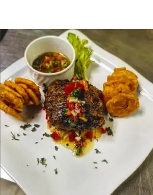 a plate of food with meat and vegetables and a sauce at Hotel Novus Caoba, Confort y calidez en Mao, Valverde