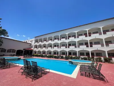 a hotel with a swimming pool in front of a building at Hotel Novus Caoba, Confort y calidez en Mao, Valverde