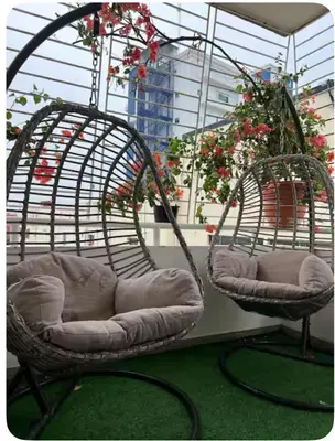 two wicker chairs sitting on a balcony with flowers at Un bonito amanecer in Santo Domingo