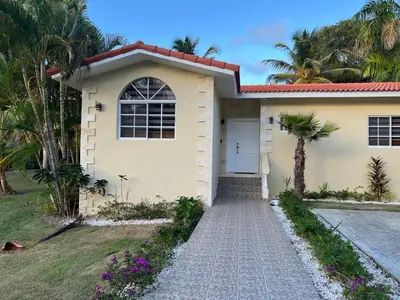 a white house with a driveway and palm trees at Villa 156, 3 bedrooms and 3 bathrooms with private pool in Sosúa