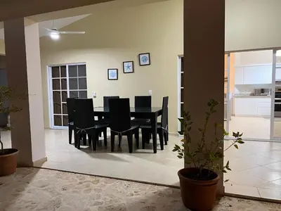 a dining room with a black table and chairs at Villa 156, 3 bedrooms and 3 bathrooms with private pool in Sosúa