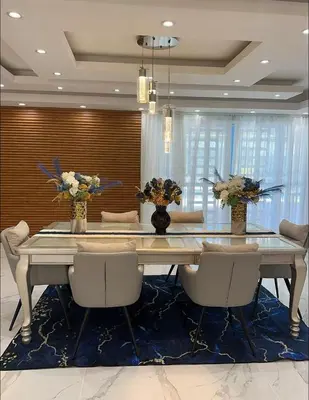 a dining room with a table with chairs and flowers at Villa Lujosa en Boca Chica in Cuevas
