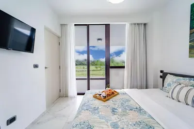 a bedroom with a bed with a tray of food on it at Vista Relax Golf & Pool View @ Cana Rock Star 210 in Punta Cana
