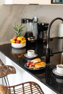 a black counter top with plates of food on it at Vista Jade Apartamento 2 Hab Vista Picina y Golf in Punta Cana