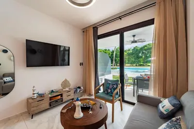 a living room with a couch and a table at Aqua Fam Swim out Suite - Pool @ Cana Rock G 117 in Punta Cana