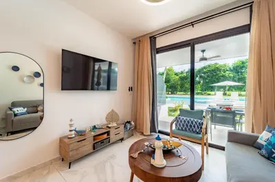 a living room with a couch and a table at Aqua Fam Swim out Suite - Pool @ Cana Rock G 117 in Punta Cana