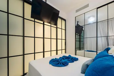 a bedroom with a white bed with blue pillows at Directo piscina jardín terraza @ Cana Rock in Punta Cana