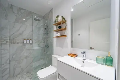 a bathroom with a shower and a sink and a toilet at Aqua Luxe @ Cana Rock terrace to pool access E-105 in Punta Cana