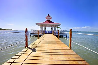 a wooden pier with a gazebo on the water at Beautiful 2 bedroom apartment Playa Nueva Romana in Boca del Soco
