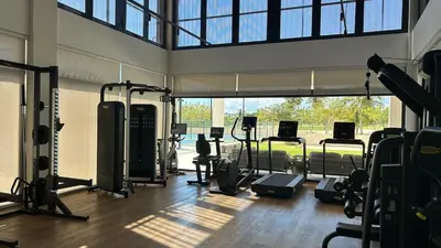 a gym with several treadmills and a large window at Beautiful 2 bedroom apartment Playa Nueva Romana in Boca del Soco