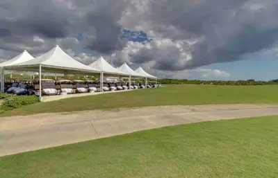 a row of white tents with cars parked under them at Beautiful 2 bedroom apartment Playa Nueva Romana in Boca del Soco