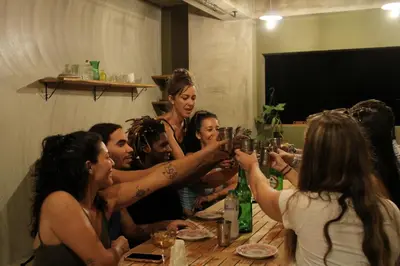 a group of people sitting around a table drinking wine at Casba Hostel in Las Terrenas