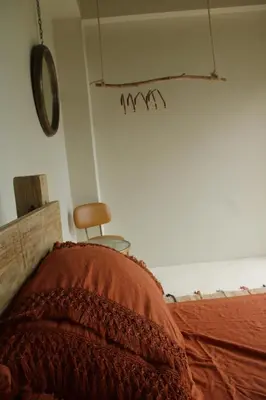 a bed with a blanket and a chair in a room at Casba Hostel in Las Terrenas